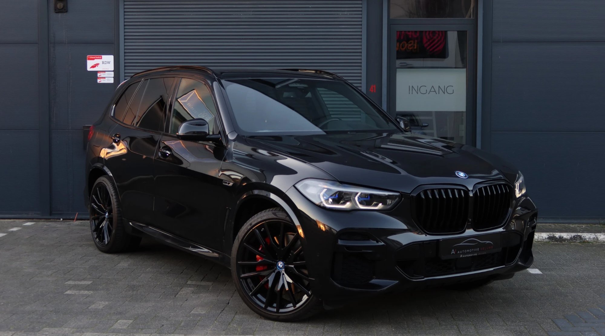 Zwarte BMW X5 voor de ingang van Automotive Veluwe in Ede